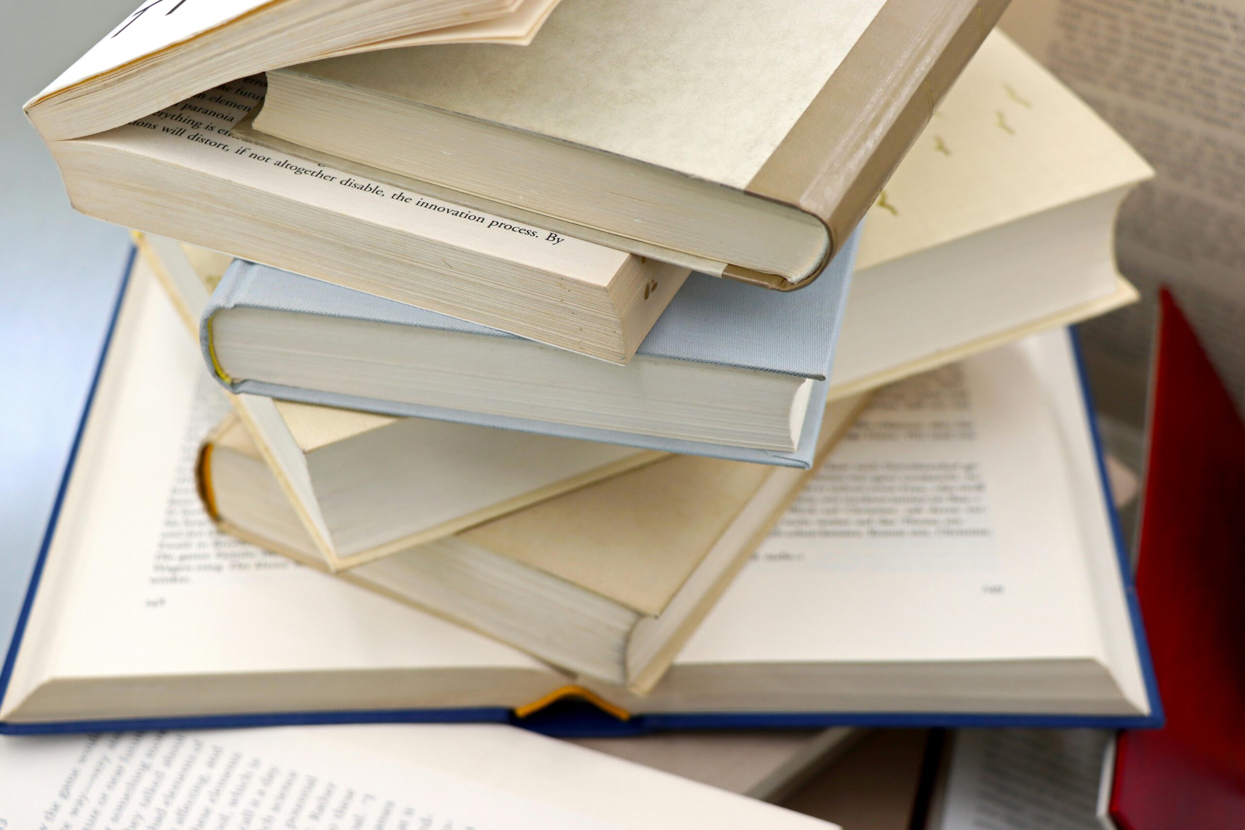 A disorganized stack of open and closed books showcasing education and study themes.